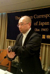 Tomohiko Suzuki shows reporters a watch with a pinhole camera on Dec. 15 at the Foreign Correspondents' Club of Japan. He used the watch to photograph the inside of the Fukushima No. 1 nuclear plant while working undercover there in July and August. (Mainichi)