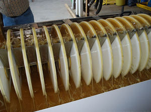 In the winning oil-removal design, spinning grooved discs pull oily water upward, where metal skimmers strain the oil away. 