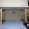 The drive coil and wireless mechanism are hidden inside a wooden box raised on two cardboa...